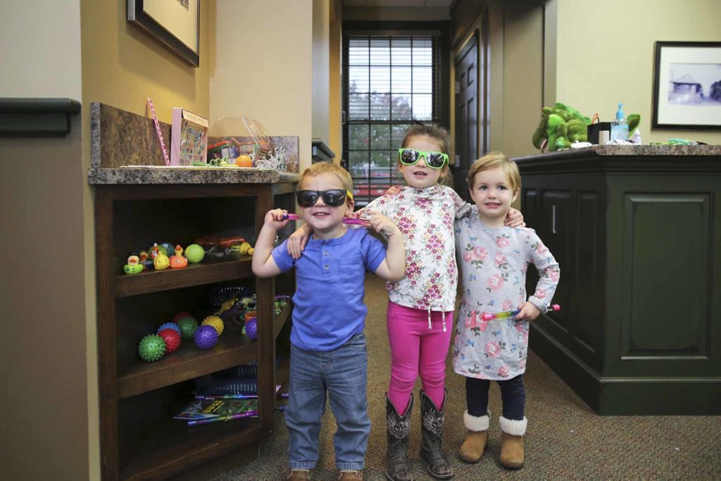 three children at the dentist office lobby