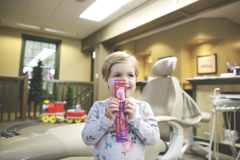 child holding a baby toothbrush