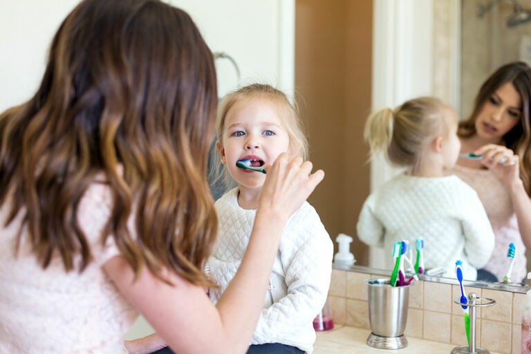 mom brushing her child's teeth
