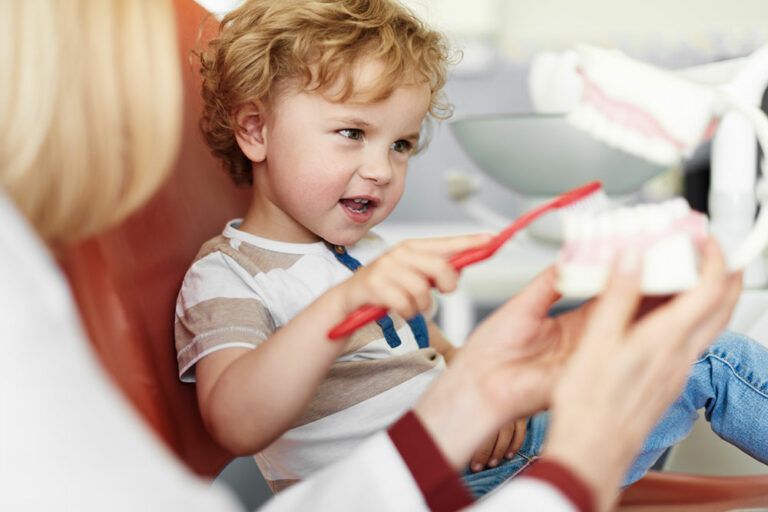 child brushing teeth in dental chair